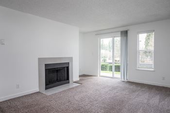 an empty living room with a fireplace and a window
